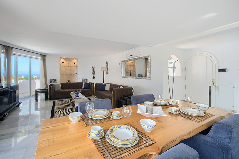 View across the dining area into the living room of Villa Cinco